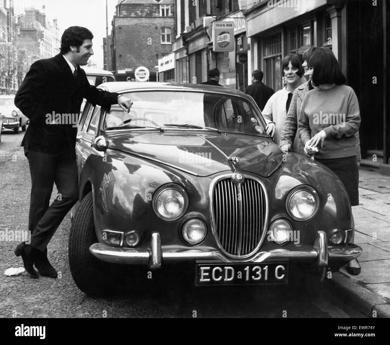 I cantanti gallesi star Tom Jones mette in mostra la sua nuova Jaguar auto a tre giovani fan oggi a Londra. Il 27 aprile 1966 Foto Stock