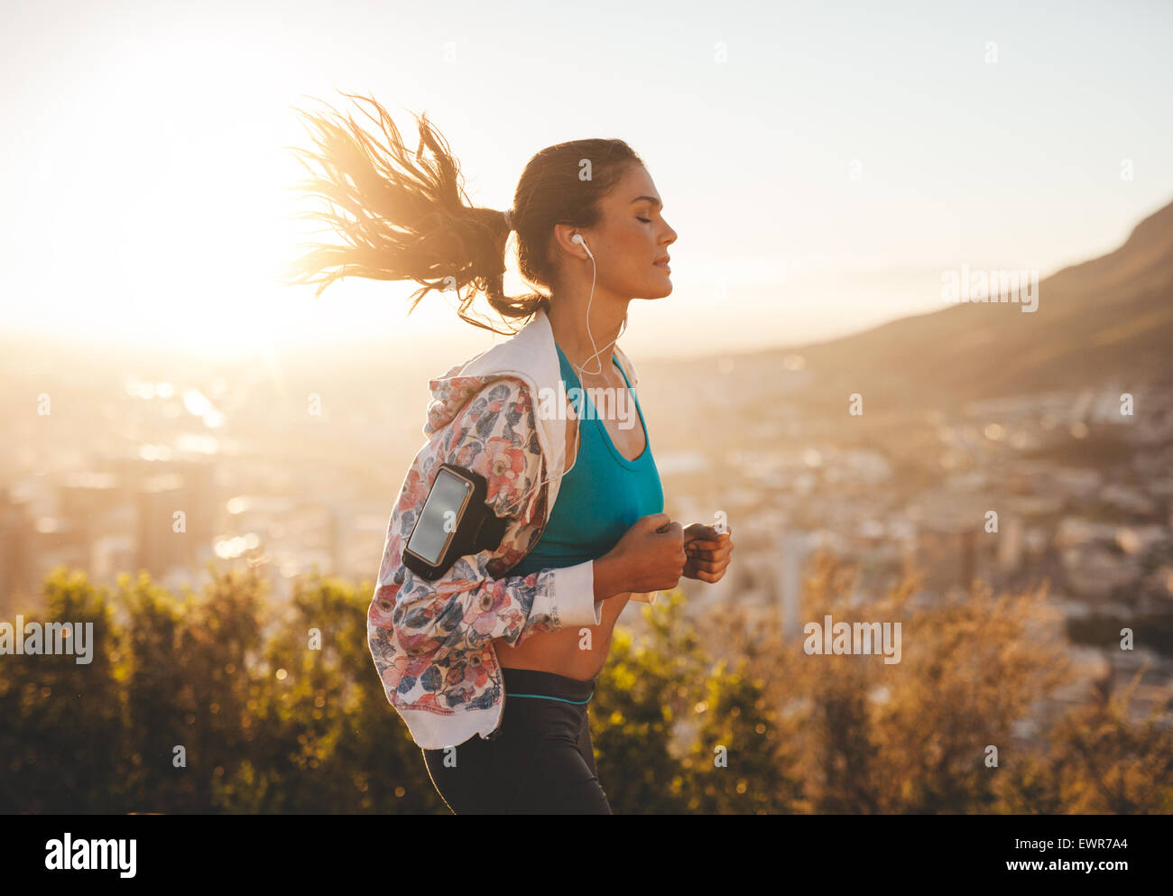 Ritratto di giovane e bella donna fuori per una corsa su una calda giornata di sole. Caucasian modello femminile jogging all'aperto. Foto Stock