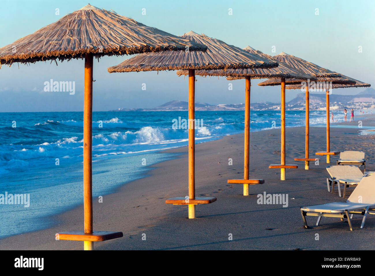 Ombrelloni paglia spiaggia in fila Rethymno, Creta, Grecia spiaggia Europa Foto Stock