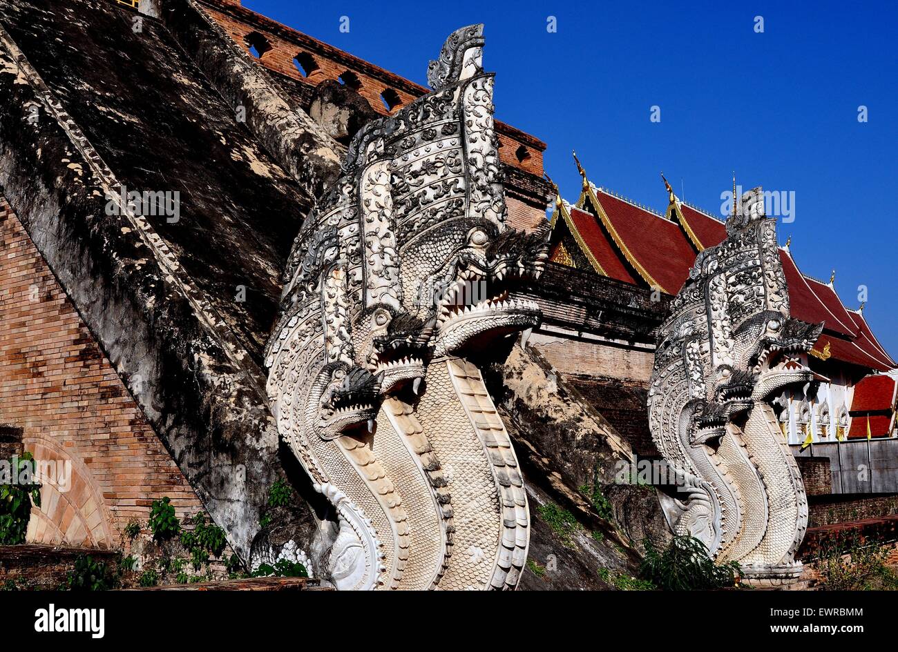 Chiang Mai, Thailandia: due immensi scolpiti Naga mitici dragoni fiancheggiano una scala nello storico Wat Chedi Luang Foto Stock