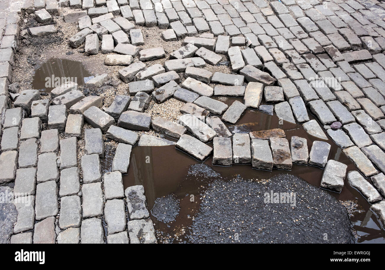Rotture di superficie di ciottoli in una strada a Soho a New York City mostra di abbandono e rovina Foto Stock