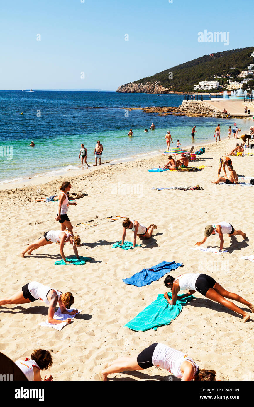 Mantenersi sulla spiaggia lezioni di pilates yoga premere pressups ups salute sano fitness Santa Eulalia Del Rio Ibiza Spagna - Spagnolo Foto Stock