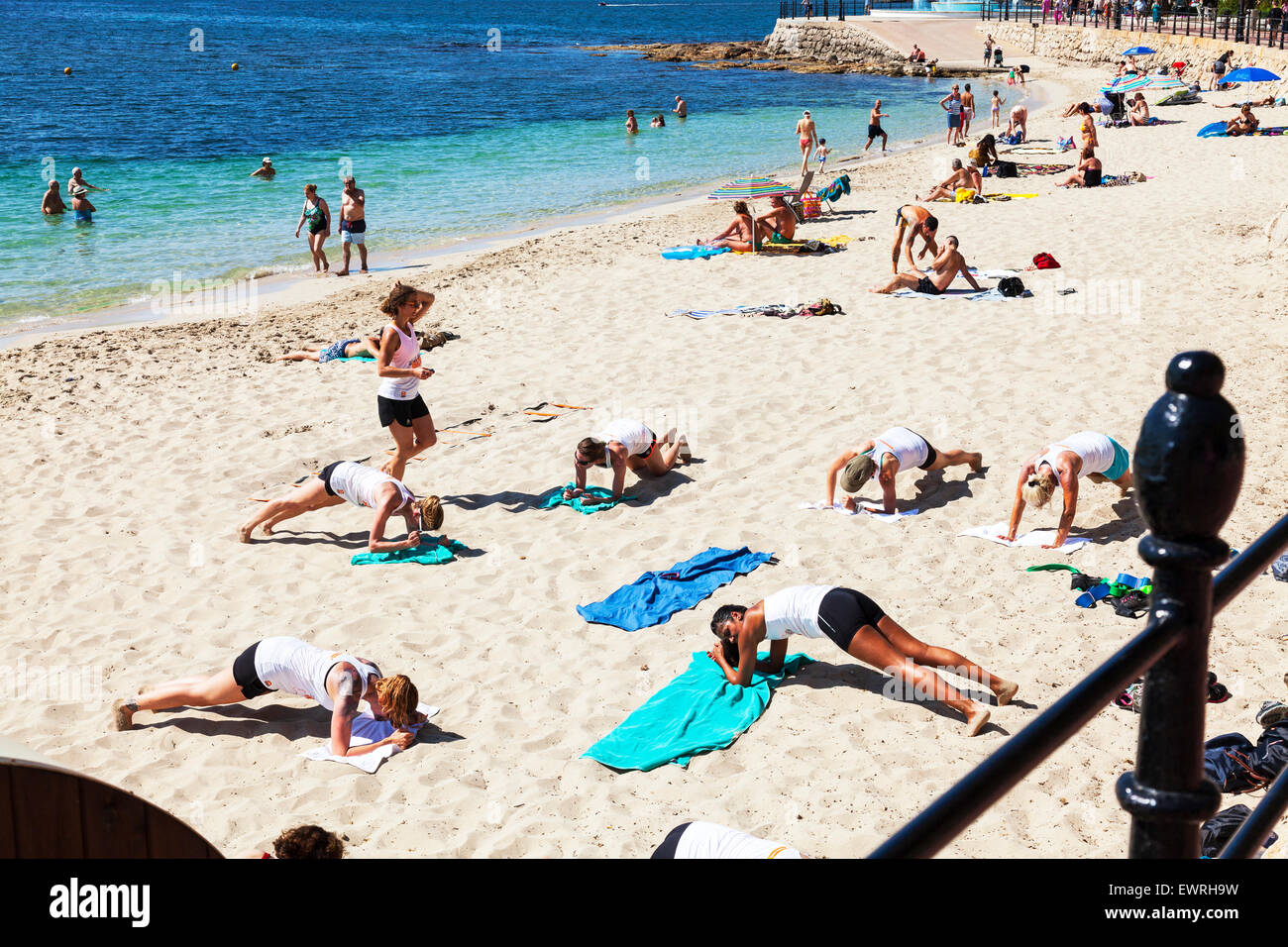 Mantenersi sulla spiaggia lezioni di pilates yoga premere pressups ups salute sano fitness fino a Santa Eulalia Del Rio Ibiza Spagna - Spagnolo Foto Stock