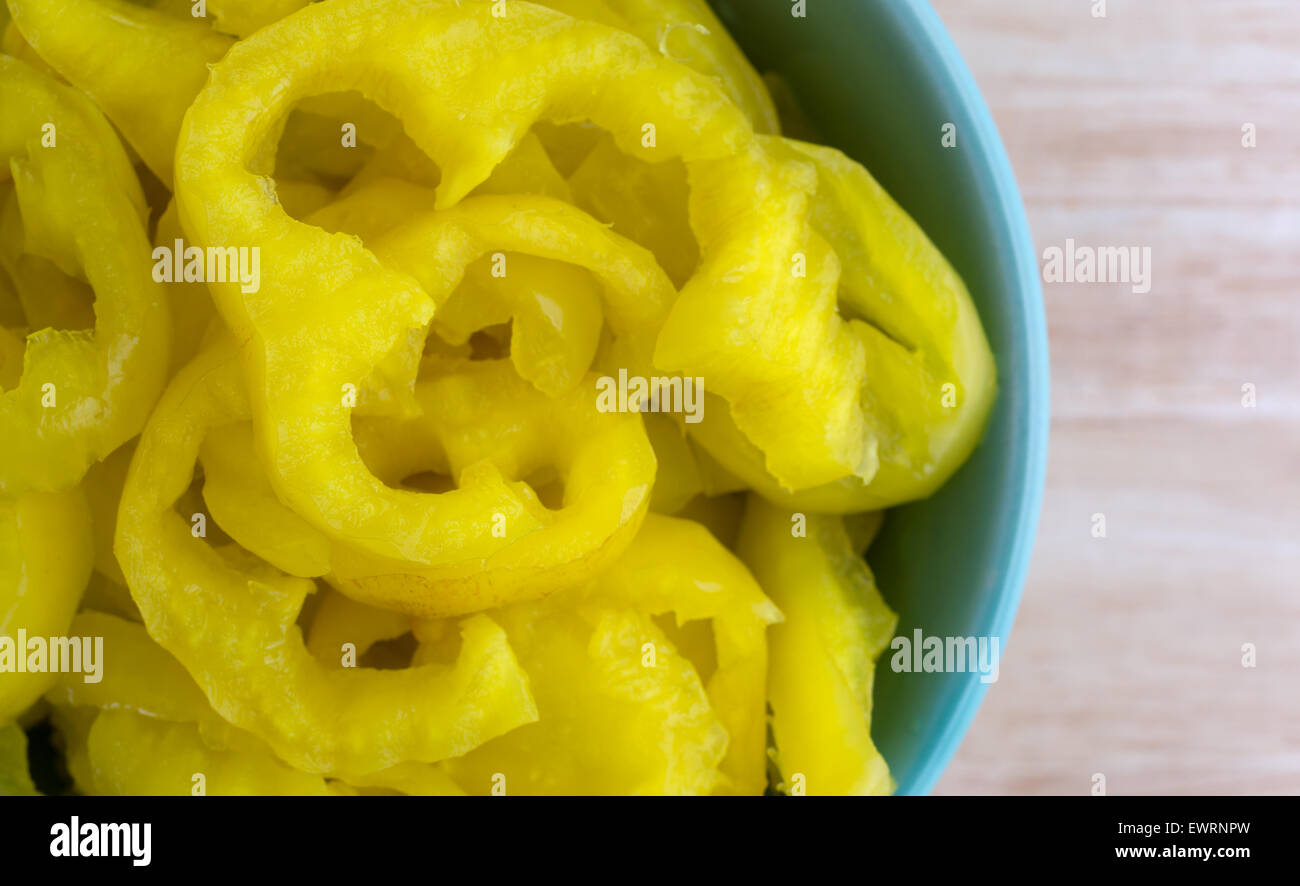 Chiudi vista superiore di taglio ondulata banana peperoni su una tavola di legno top illuminato con finestra naturale luce Foto Stock