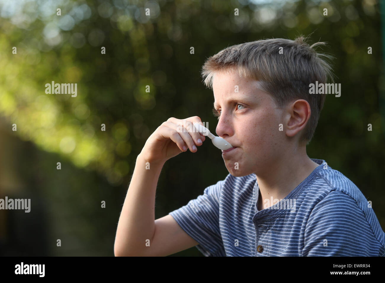 Un ragazzo di prendere la medicina antistaminico per aiutare i sintomi del raffreddore da fieno e allergie Foto Stock