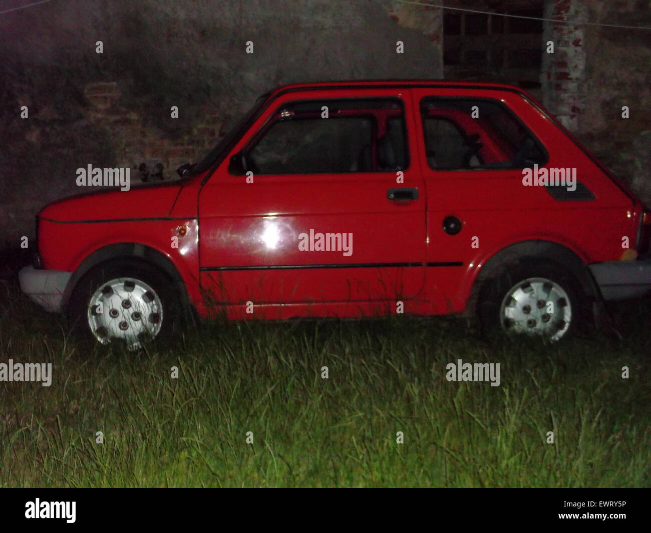 Vecchia Fiat 126P di notte - ricoperta da erba. Foto Stock