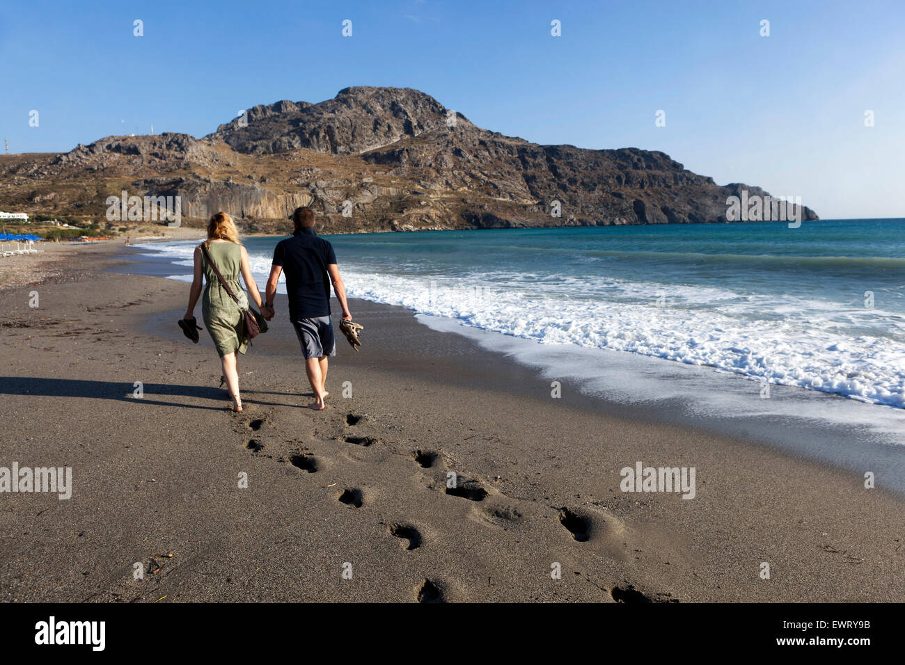 Passi sulla sabbia, coppia che cammina sulla spiaggia di Plakias Creta, vista sul retro della spiaggia della Grecia Foto Stock