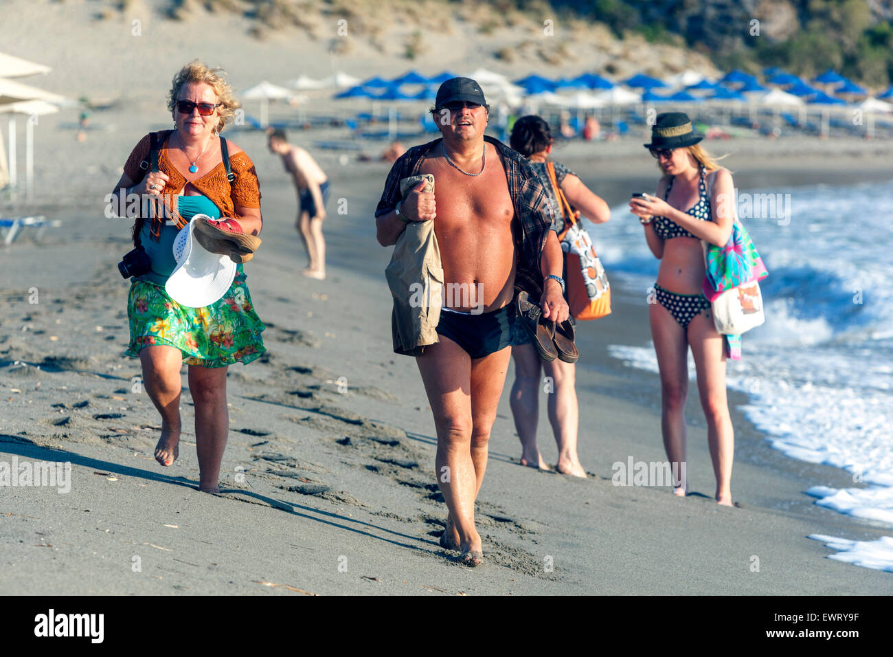 Persone che camminano sulla spiaggia di Plakias, Creta meridionale Grecia vacanzieri Europa Foto Stock