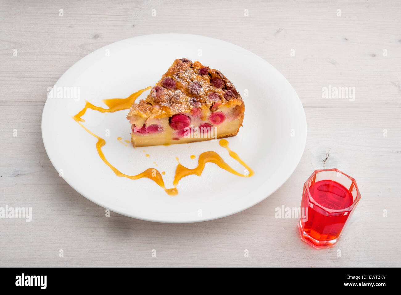 Clafoutis di ciliegio, tradizionale francese dessert. Pastella cotta pudding con amarene, spolverato con zucchero a velo servite con Foto Stock