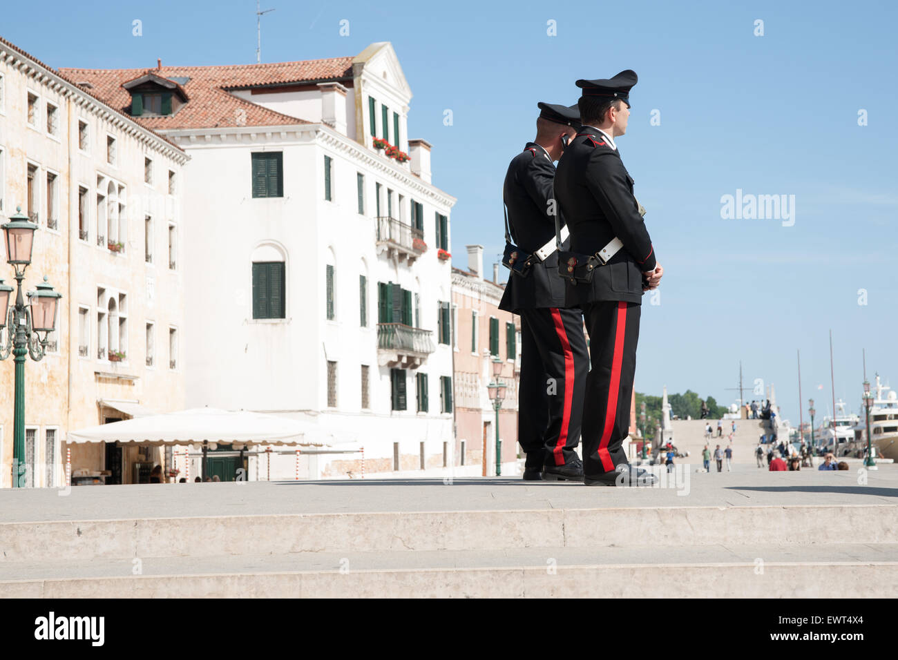 Due Carabinieri stare a guardare gli eventi e mantenendo la legge sui passi vicino Venezia waterfront. Foto Stock