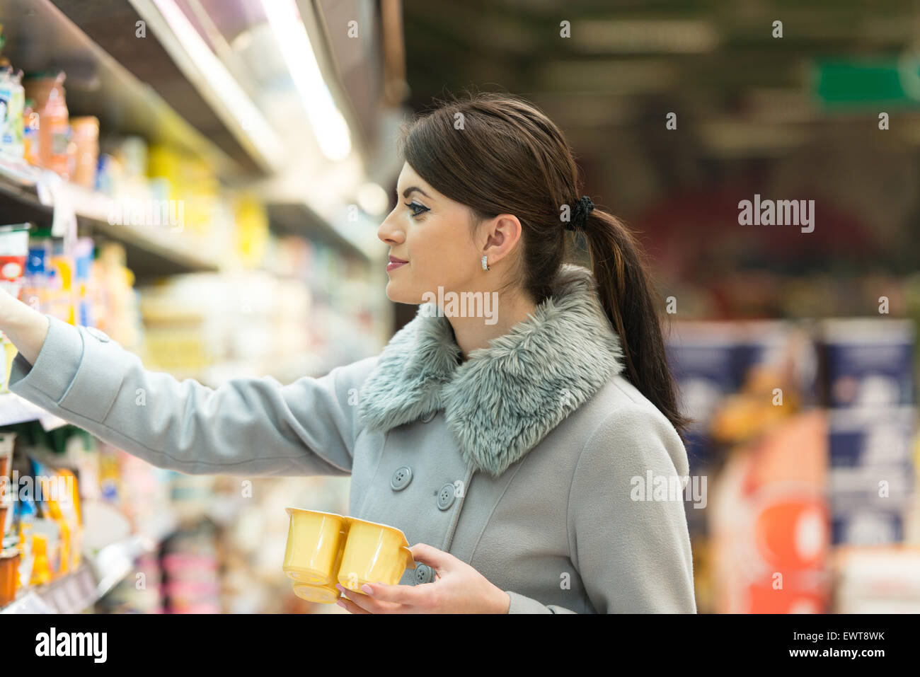 Bella Giovane Donna Shopping per frutta e verdura nel reparto di produzione di un negozio di alimentari - Supermercato - superficiali o profondi Foto Stock