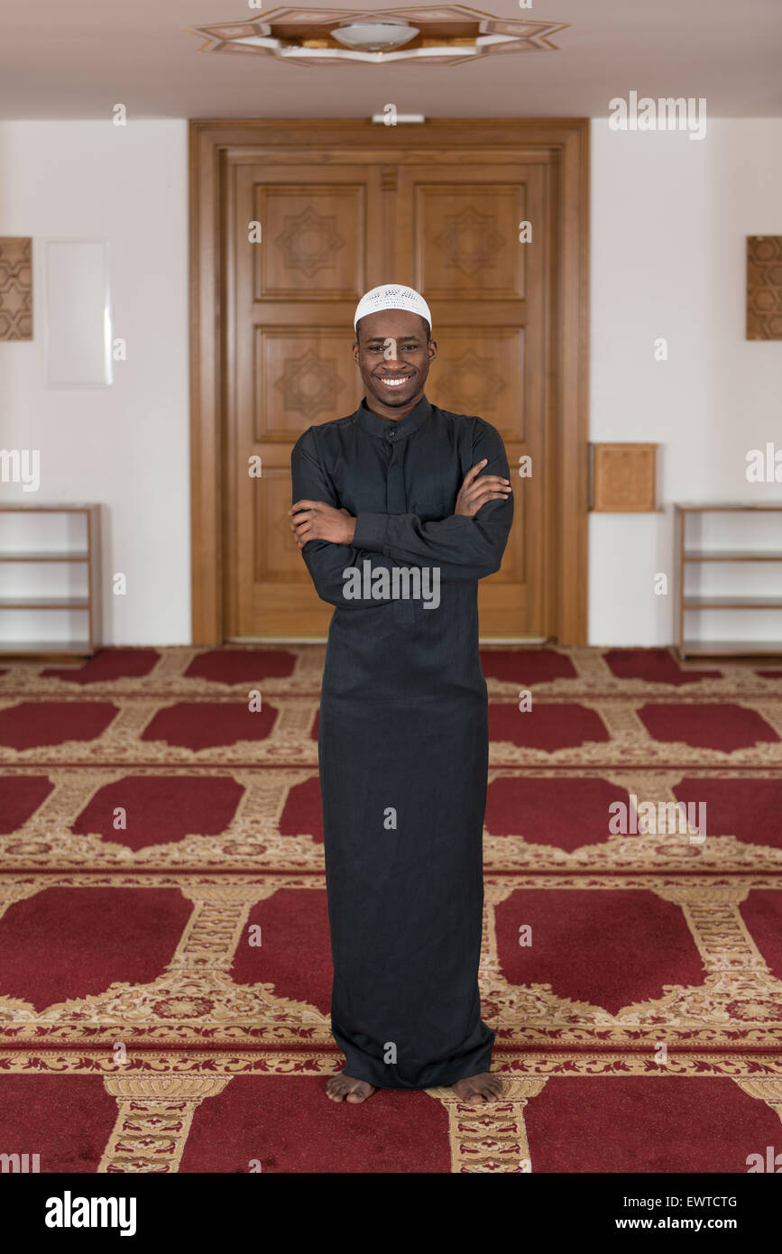 Musulmani africani uomo rendendo tradizionale preghiera a Dio indossando un cappello tradizionale Dishdasha Foto Stock