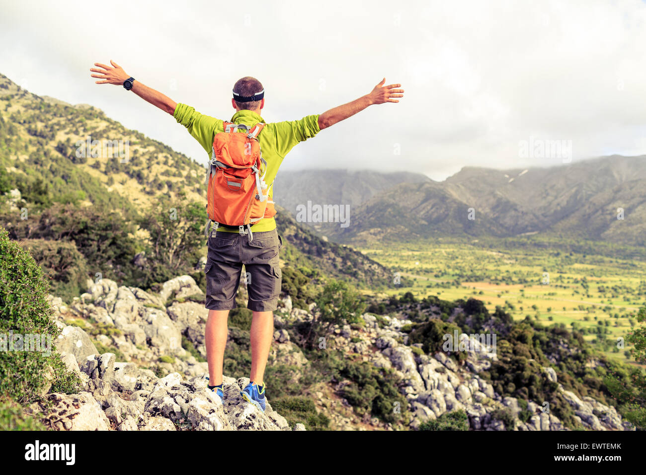 Felice alpinista escursionista vincendo il raggiungimento di obiettivi di vita, l'uomo di successo al vertice, il successo del concetto di affari. Giovani runner escursionista le braccia in alto o Foto Stock