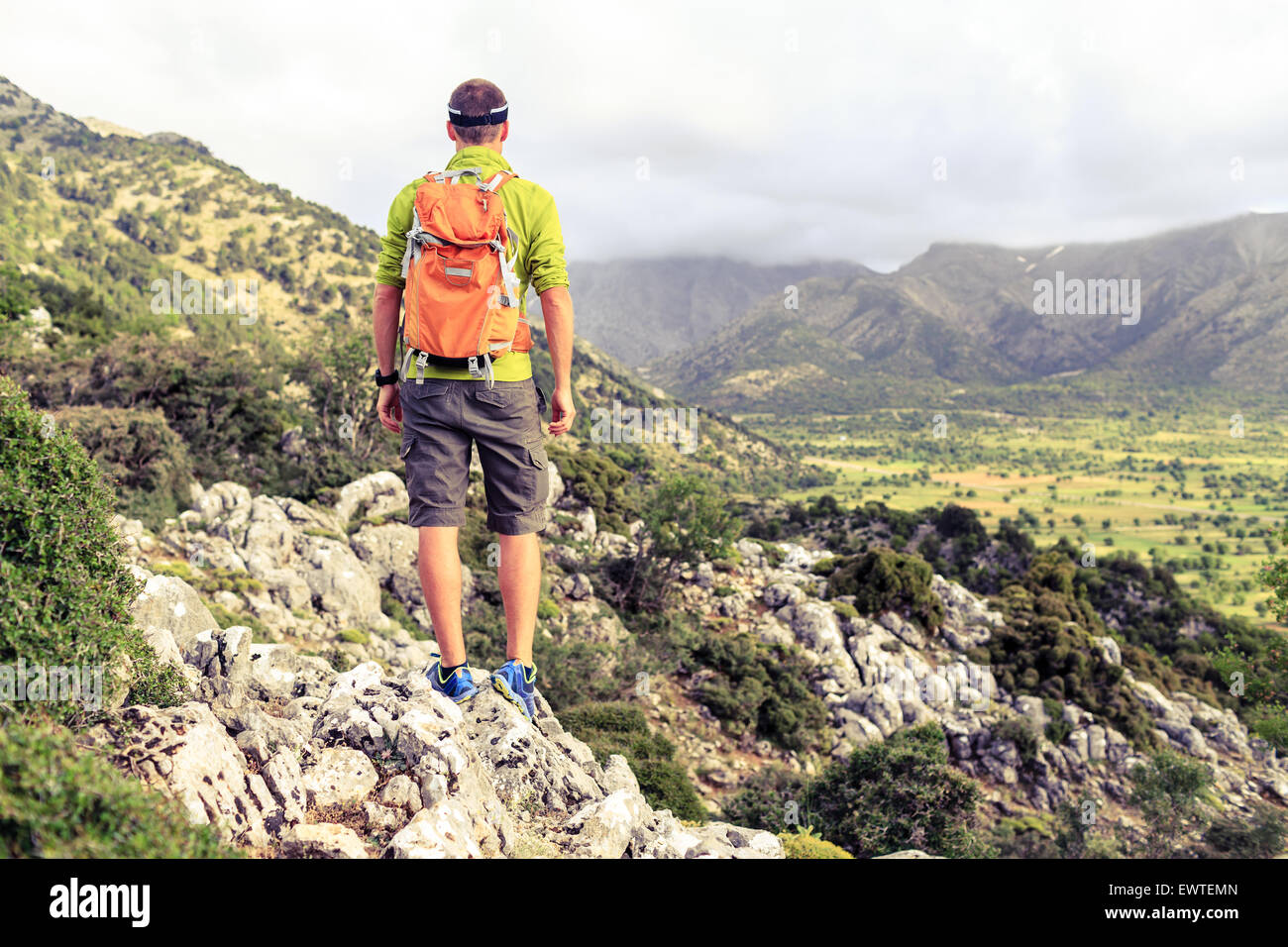 Escursionismo uomo guardando belle montagne paesaggio di ispirazione. Escursionista trekking con zaino sul sentiero roccioso sentiero. Un sano Foto Stock
