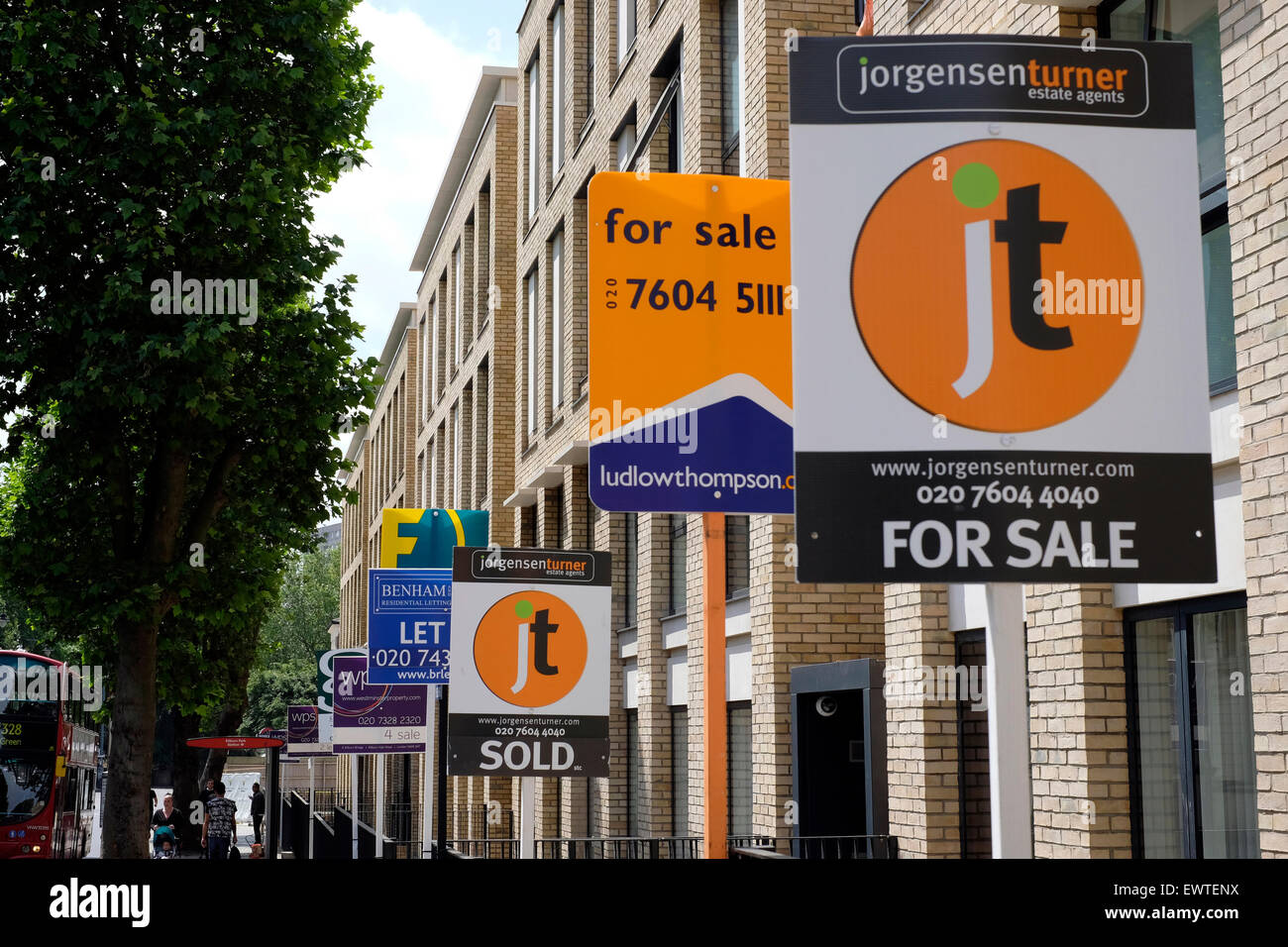 Diversi agenti immobiliari visualizzare i loro segni di vendita al di fuori di nuova costruzione appartamenti In Kilburn, Londra Foto Stock