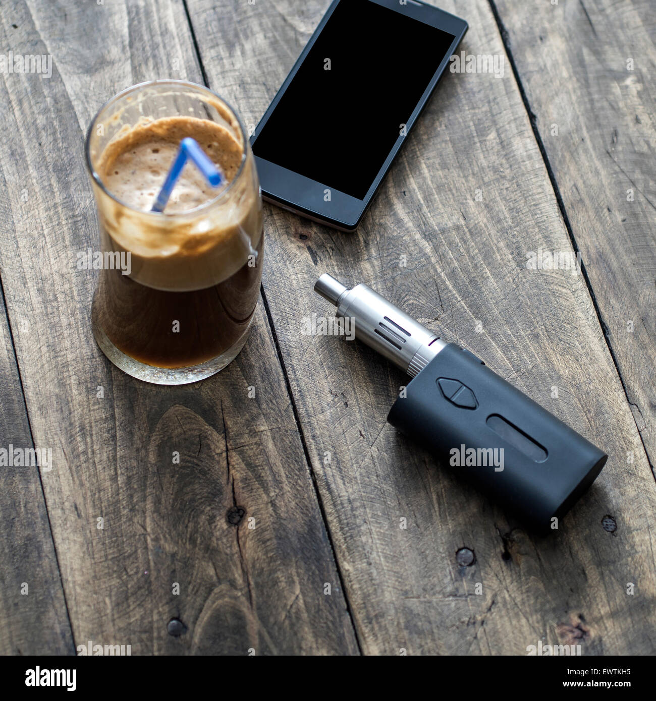 Gli uomini di accessori , vista dall'alto su un sfondo di legno, contiene il telefono, caffè e e-sigaretta Foto Stock