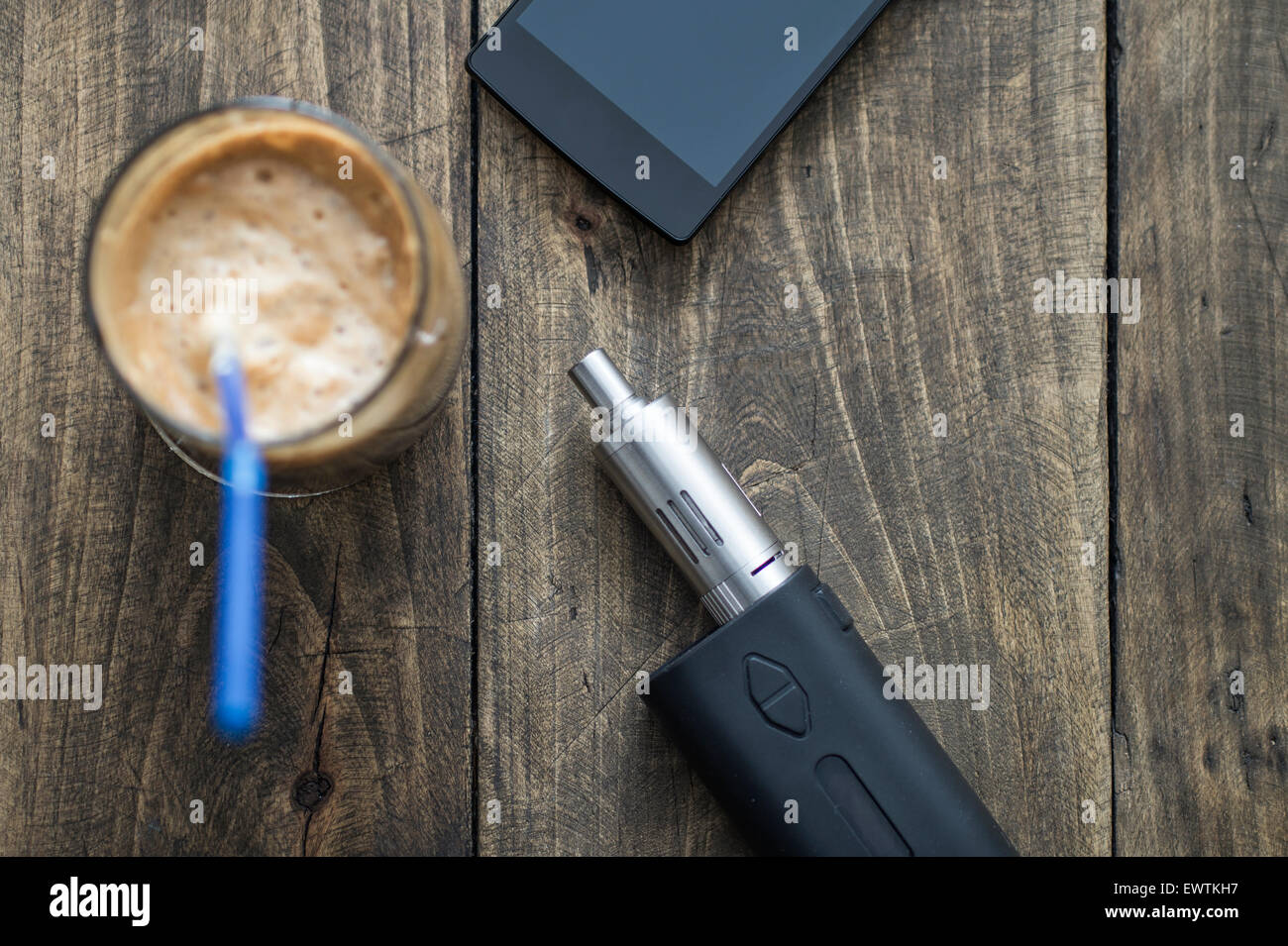 Gli uomini di accessori , vista dall'alto su un sfondo di legno, contiene il telefono, caffè e e-sigaretta Foto Stock