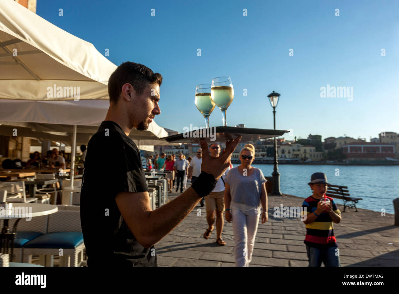 Cameriere greco serve vino vecchio porto veneziano Chania Creta Grecia, Europa Foto Stock