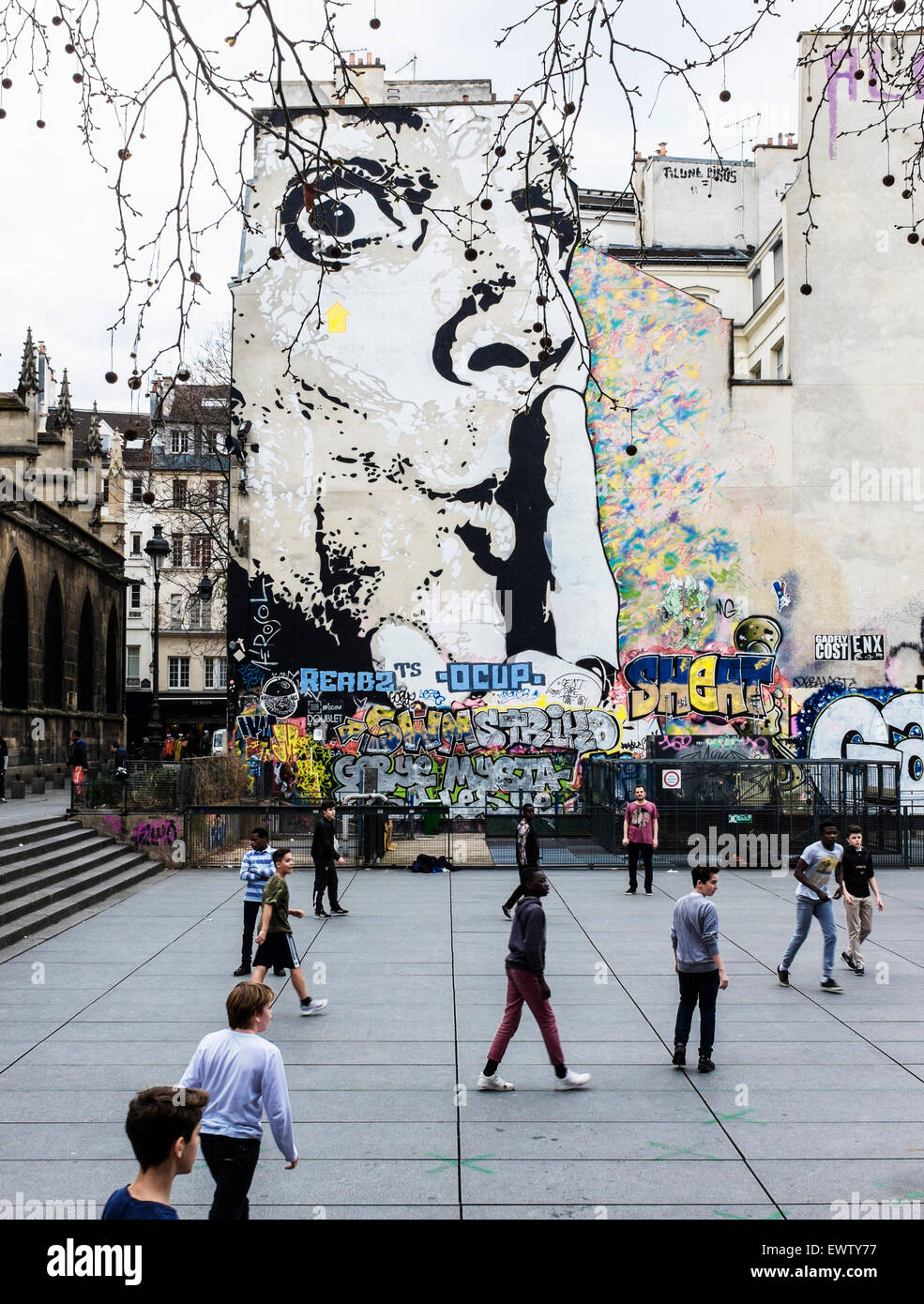 I bambini che giocano a calcio & Urban street art di Jef, volto con il dito indice sulla bocca, Chuuuttt Shhhh! - Posizionare Stravinsky Parigi Foto Stock