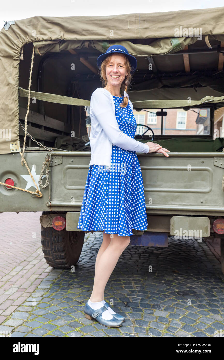 Unione donna di mezza età vestito in abiti blu in posa contro jeep militari Foto Stock