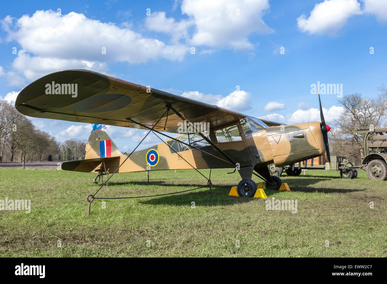Vecchio aereo militare su erba verde con cielo blu e nuvole bianche in mostra all'aperto Foto Stock