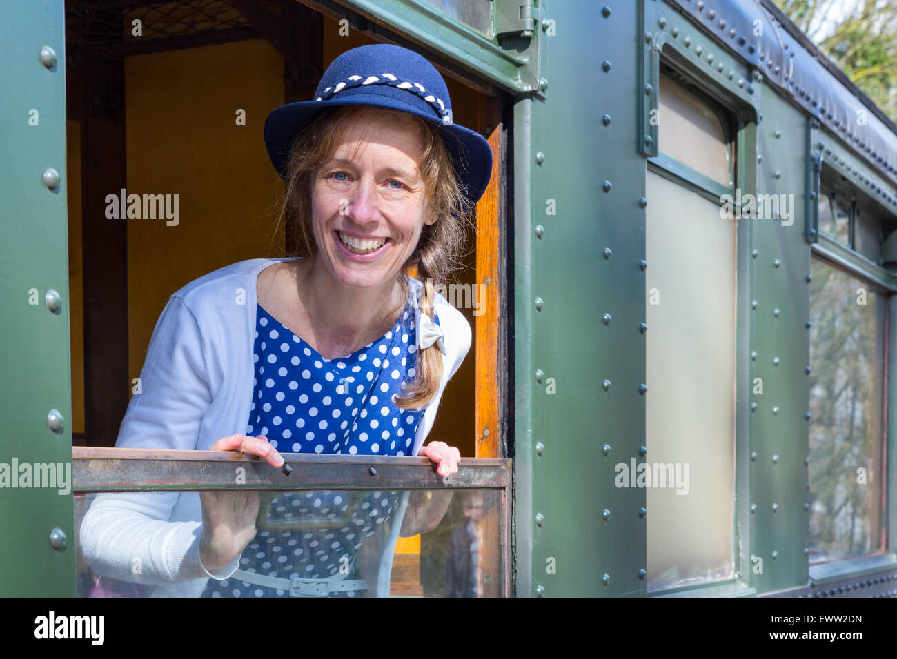 Caucasian donna di mezza età Vestito in blu di vecchio stile vestiti nella finestra del treno a vapore Foto Stock