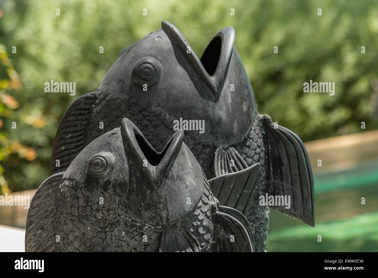 Bronze asian Dancing Statue di pesce a bordo piscina Foto Stock