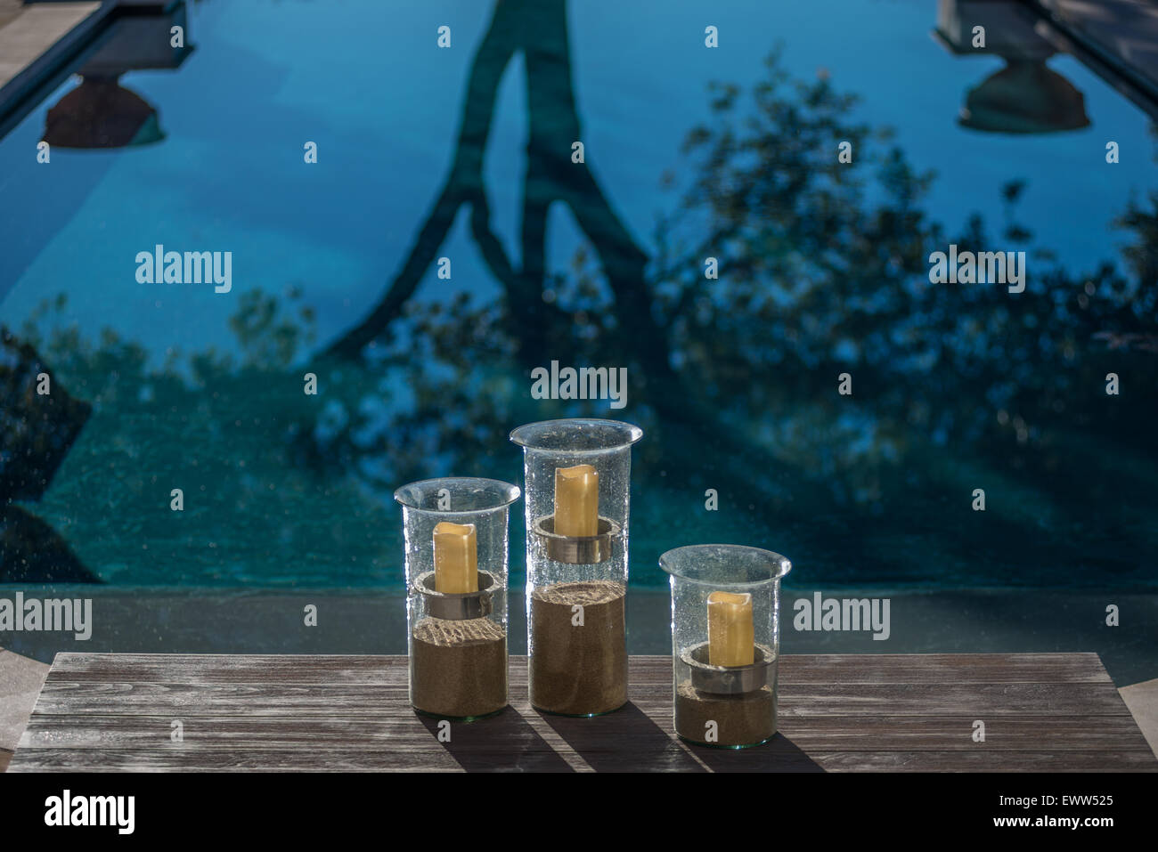 Candele votive sospese al di sopra di sabbia in tre cilindrica vasi di vetro Foto Stock