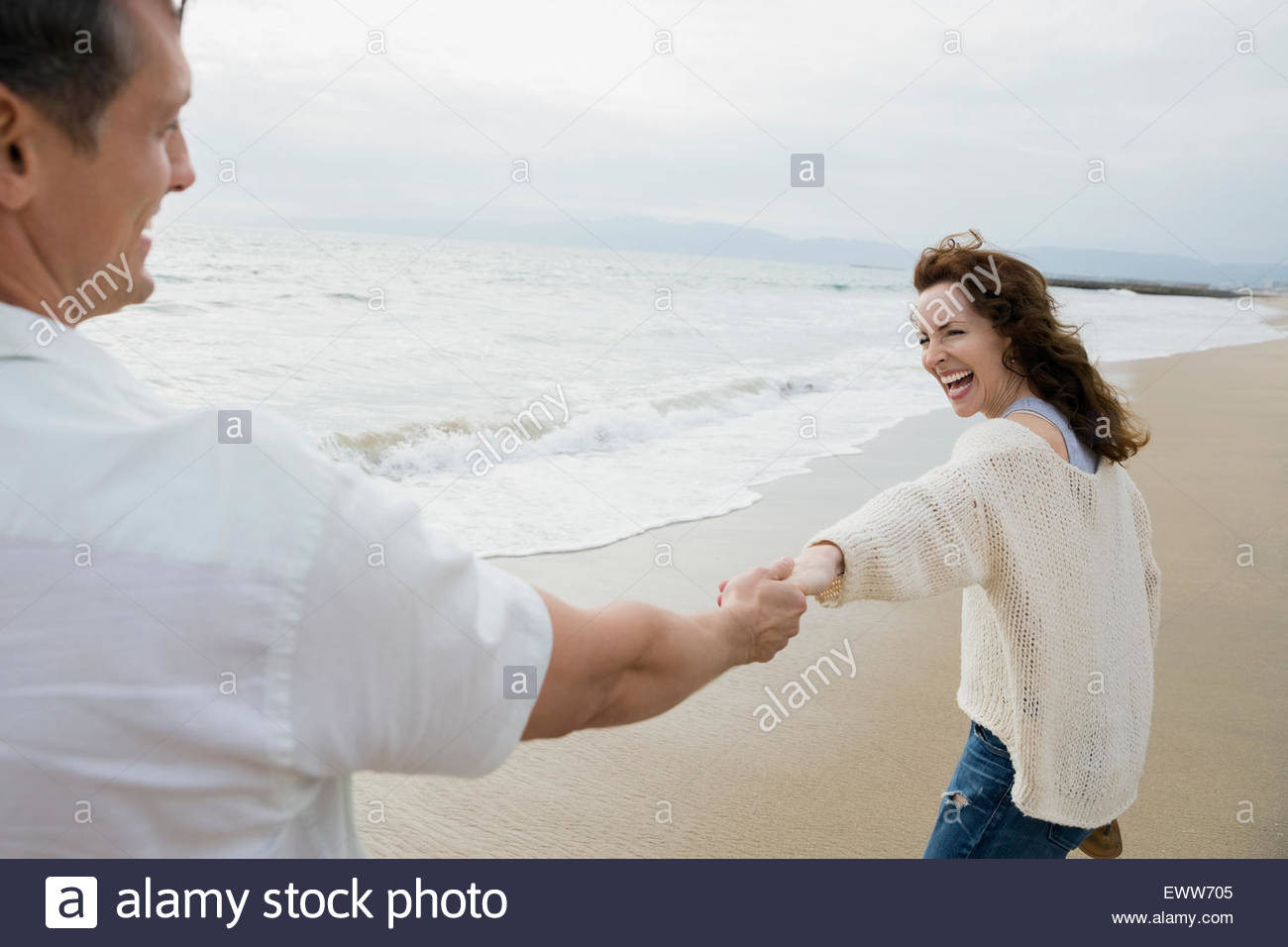 Giocoso giovane tenendo le mani sulla spiaggia Foto Stock