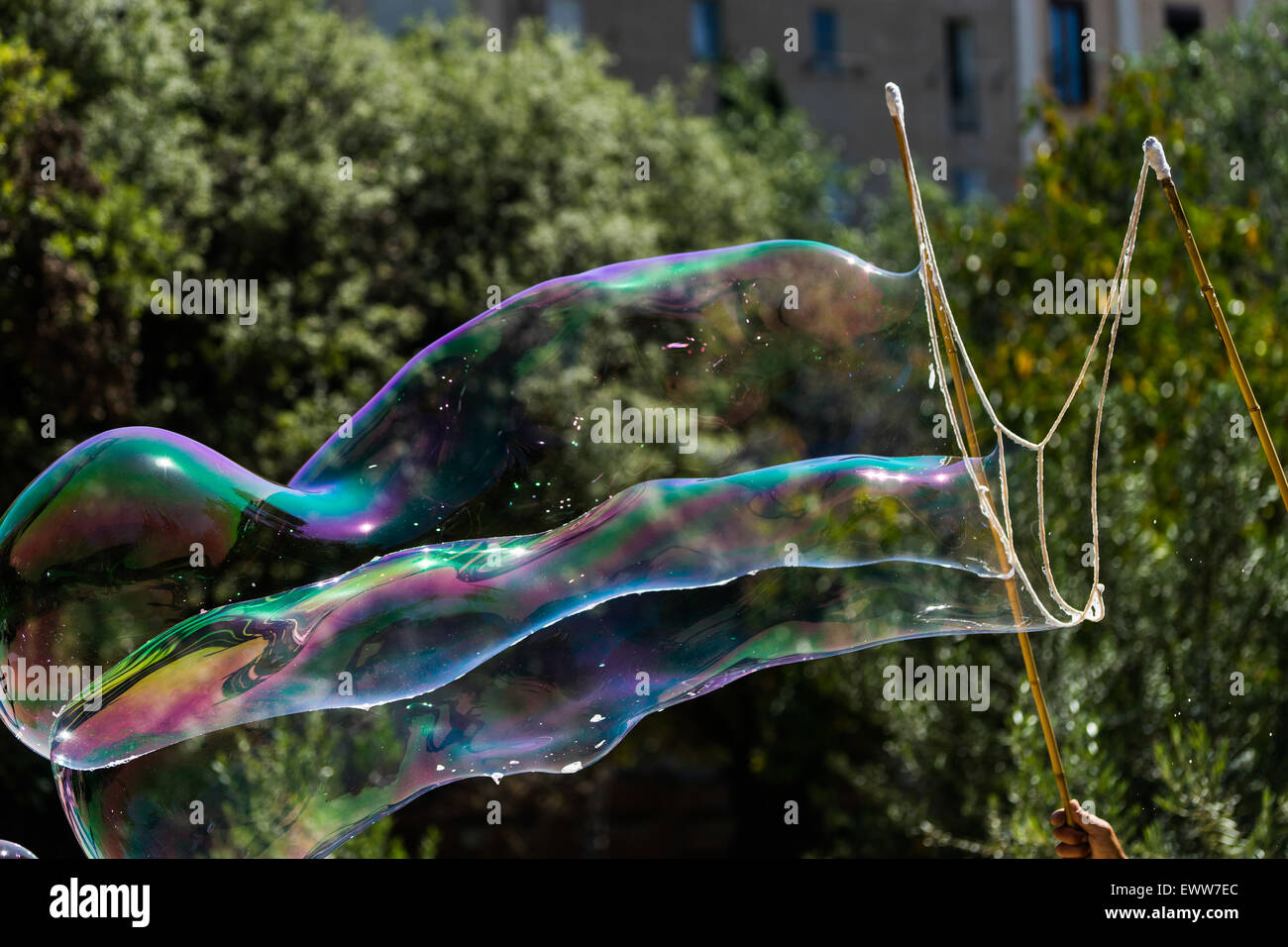 Una grande bolla essendo soffiato in un parco di Barcellona. Foto Stock