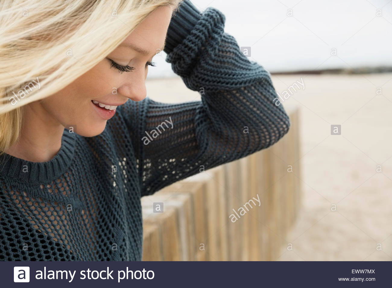 Donna bionda guardando giù in spiaggia Foto Stock