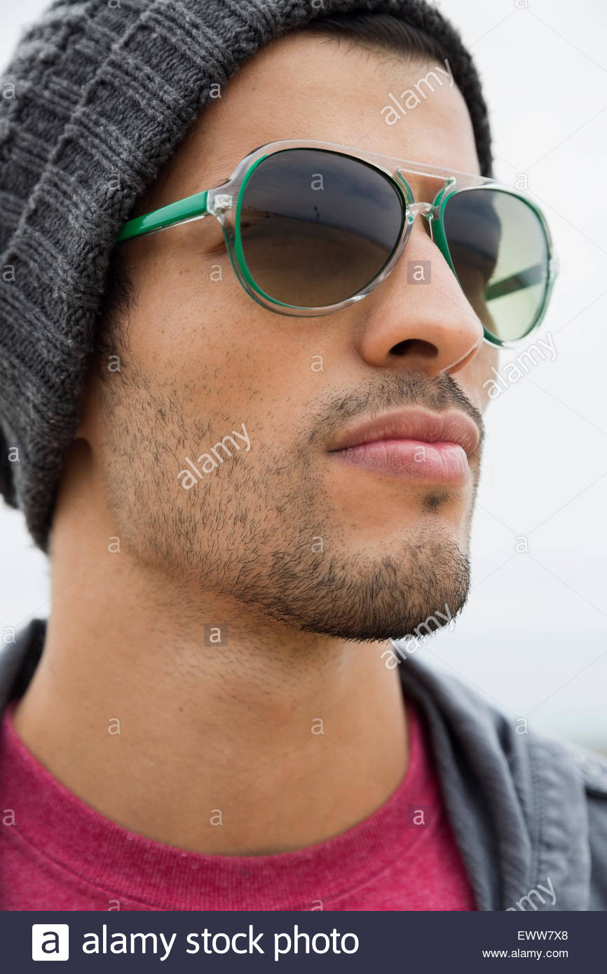 Close up uomo indossando occhiali da sole che guarda lontano Foto Stock