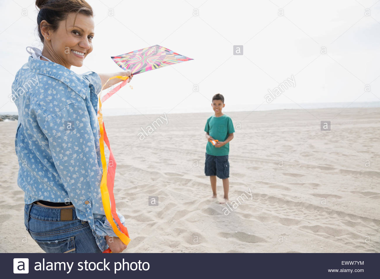 Ritratto di madre e figlio aquilone volante presso la spiaggia Foto Stock