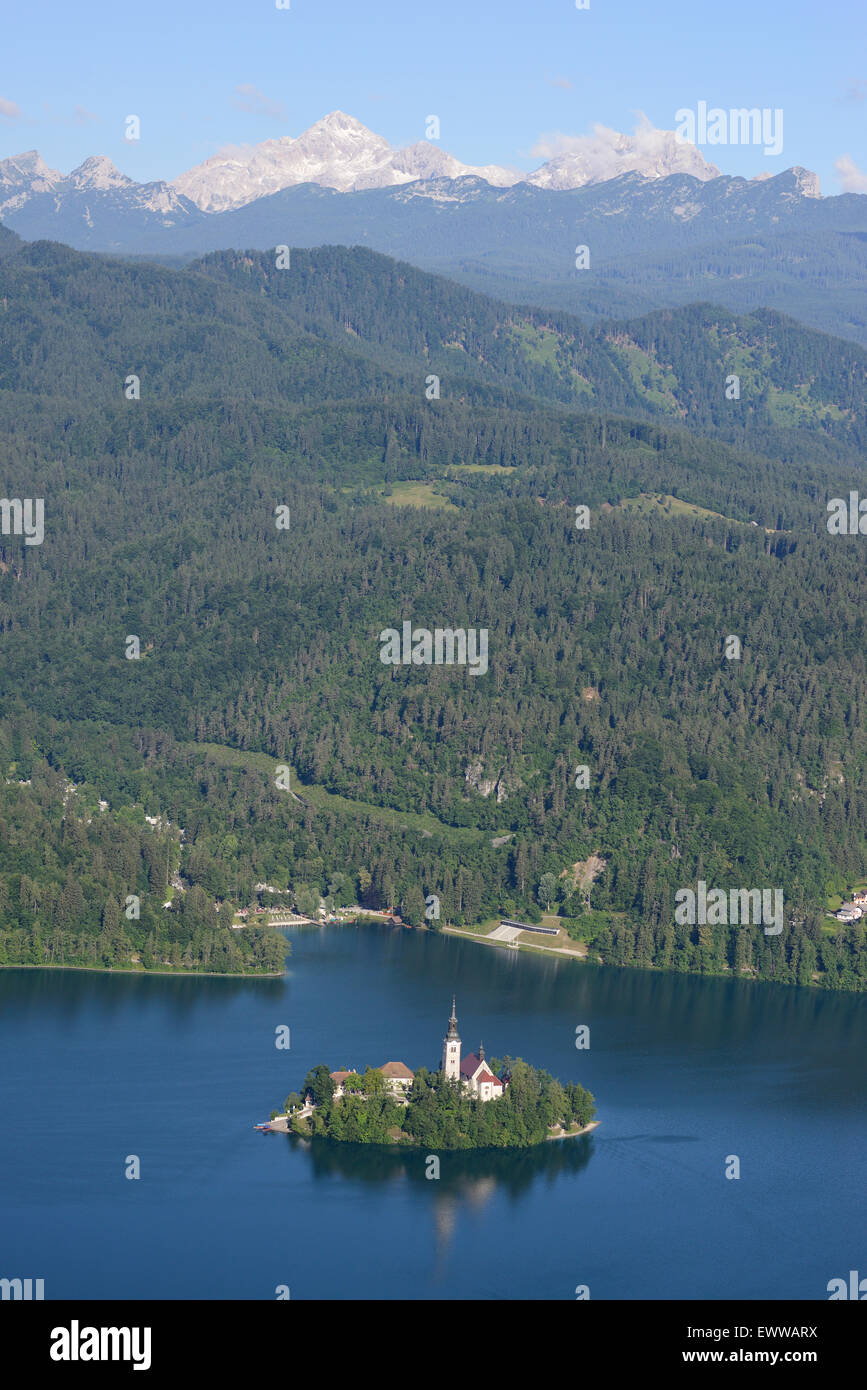 VISTA AEREA. Isola di Bled sul lago di Bled. Parco Nazionale del Triglav in lontananza. Bled, alta Carniola, Slovenia. Foto Stock