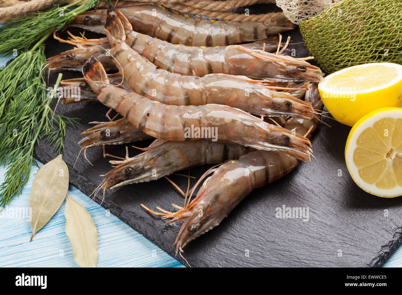 Crudo fresco gamberoni e attrezzature per la pesca sul tavolo di legno Foto Stock