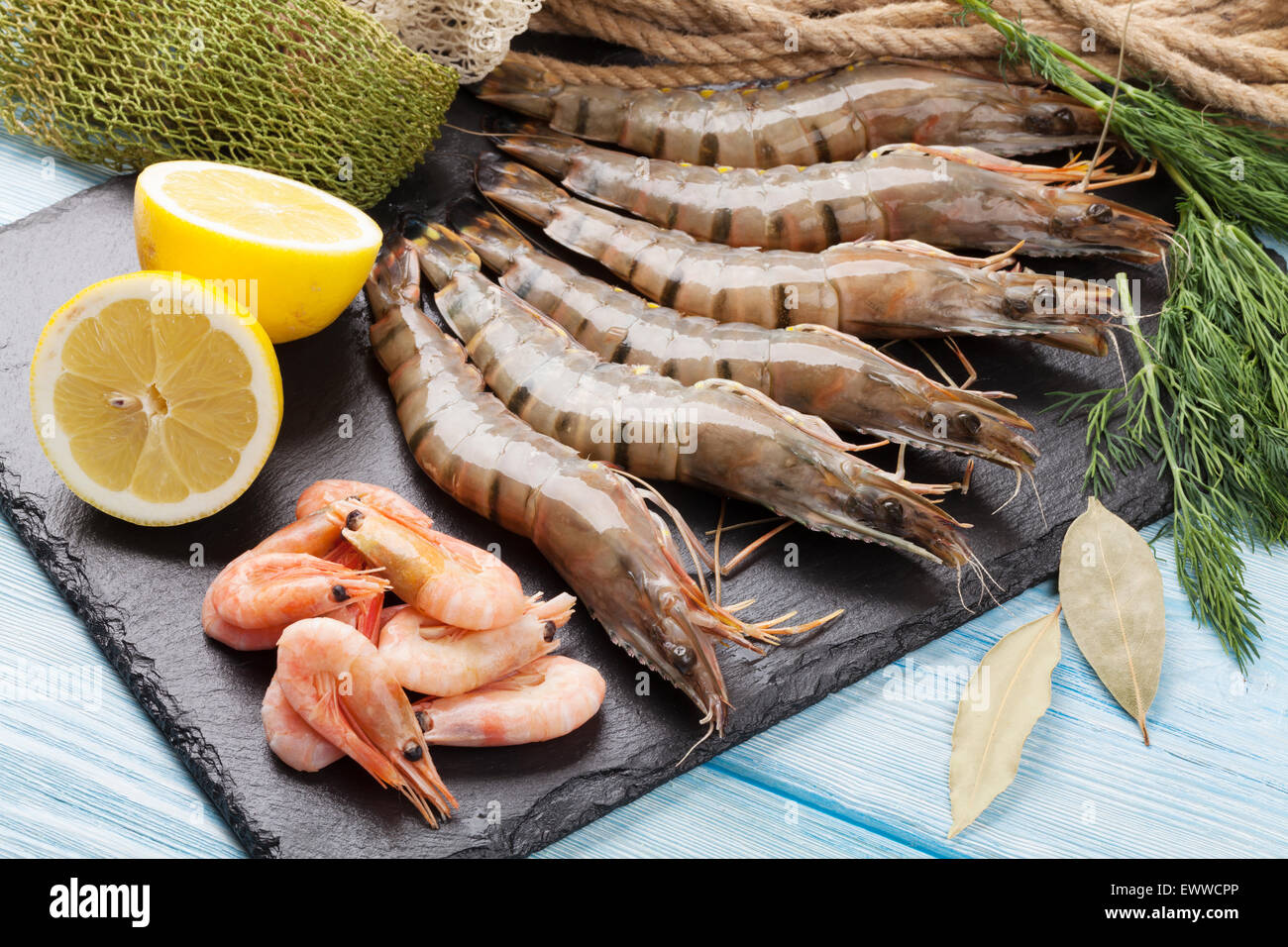 Crudo fresco gamberoni e attrezzature per la pesca sul tavolo di legno Foto Stock