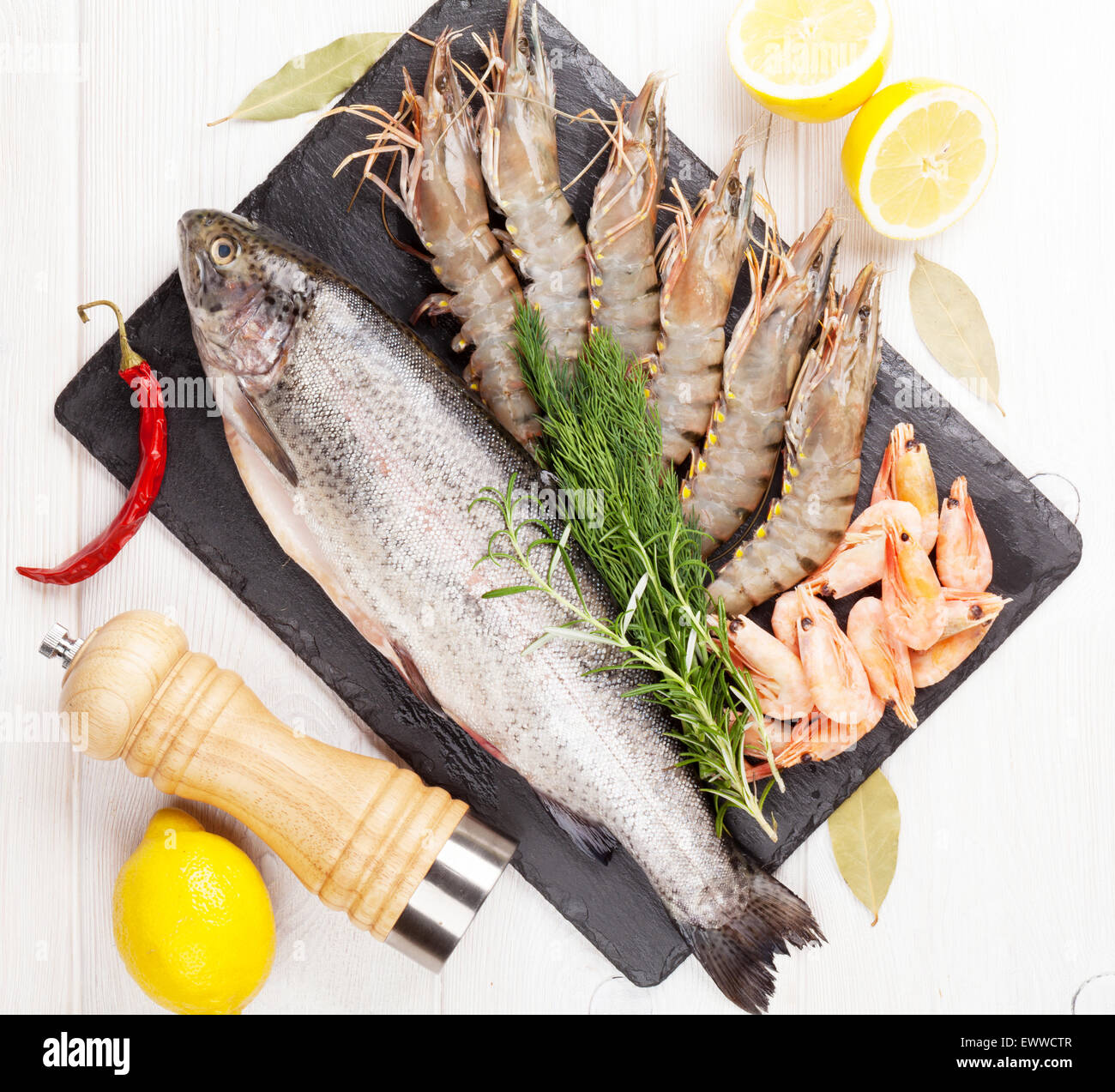 Crudo fresco il cibo del mare con spezie sulla lastra di pietra su un tavolo di legno dello sfondo. Vista superiore Foto Stock