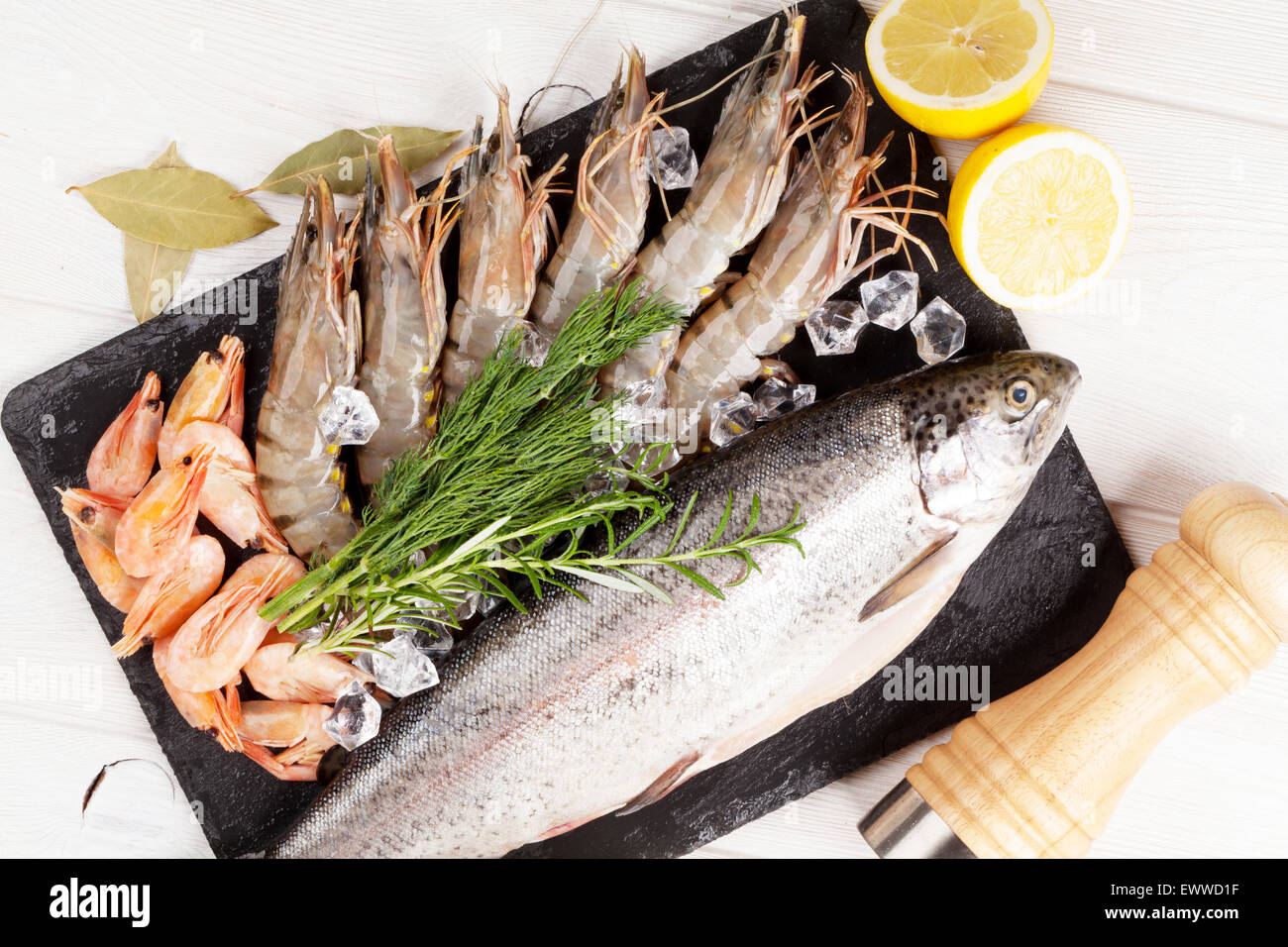 Crudo fresco il cibo del mare con spezie sulla lastra di pietra su un tavolo di legno dello sfondo. Vista superiore Foto Stock