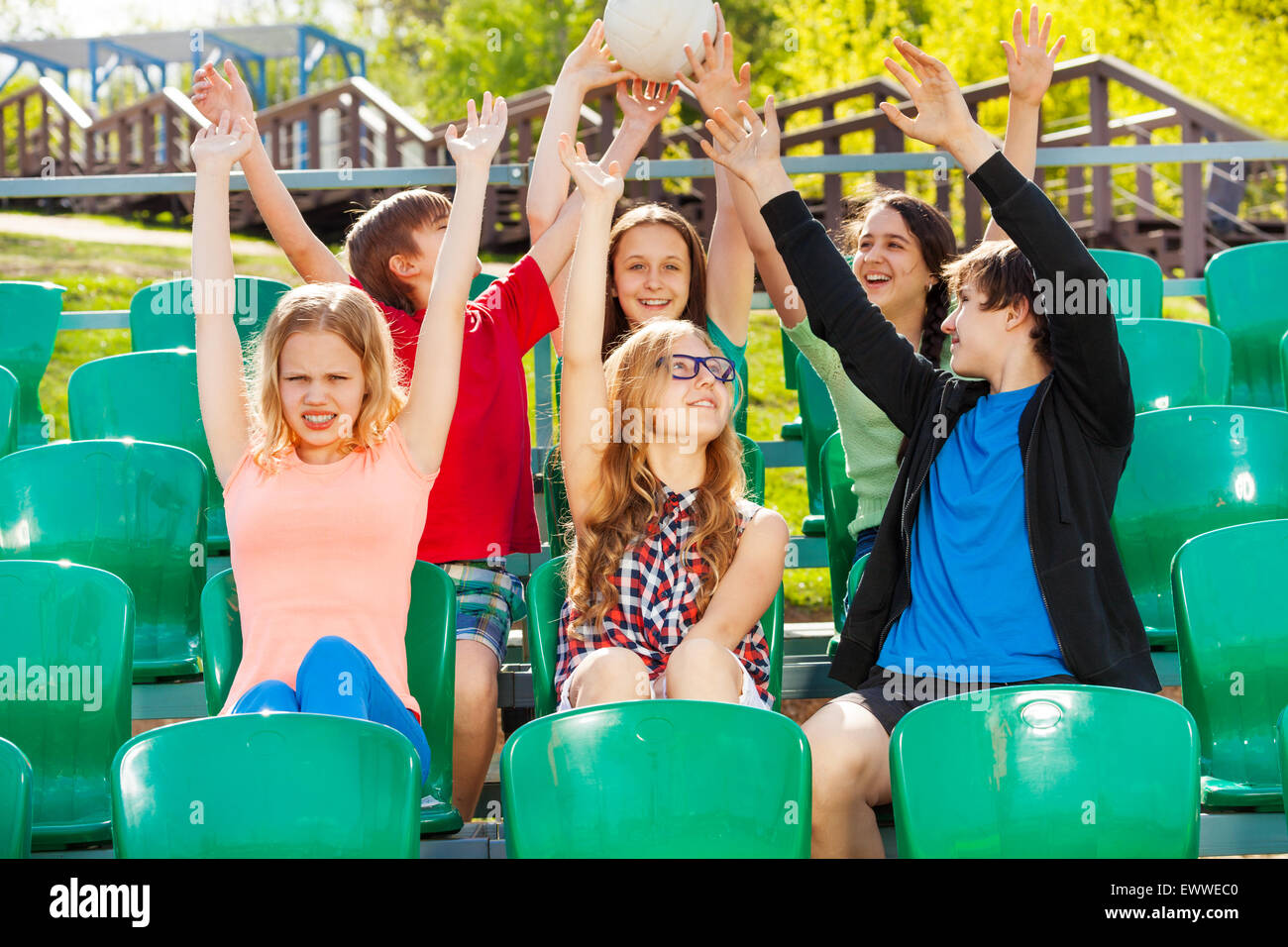 Teens tenere la sfera e il tifo per il team di tribune Foto Stock