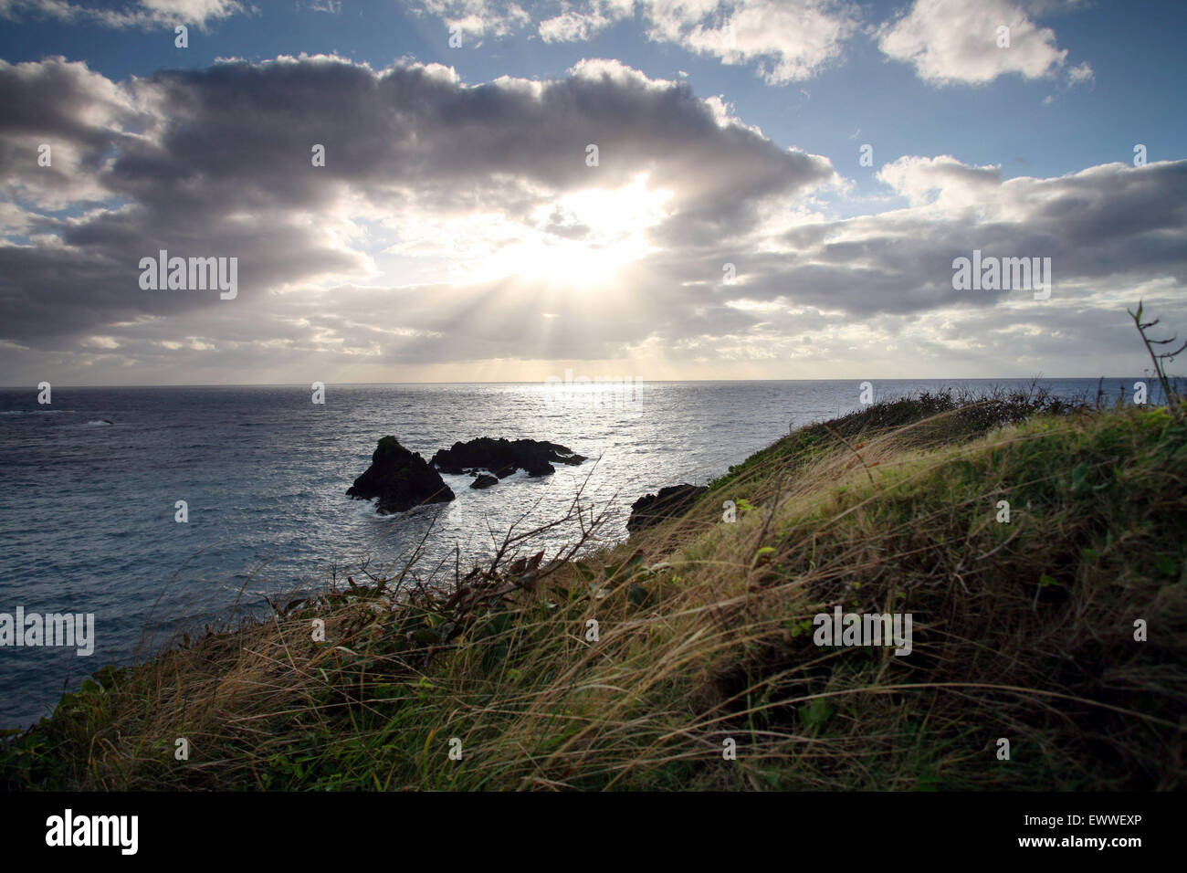 Il sorgere del sole sopra il Pacifico lungo alcune scogliere vicino alla città di Hana sull'isola di Maui, Hawaii. Foto Stock