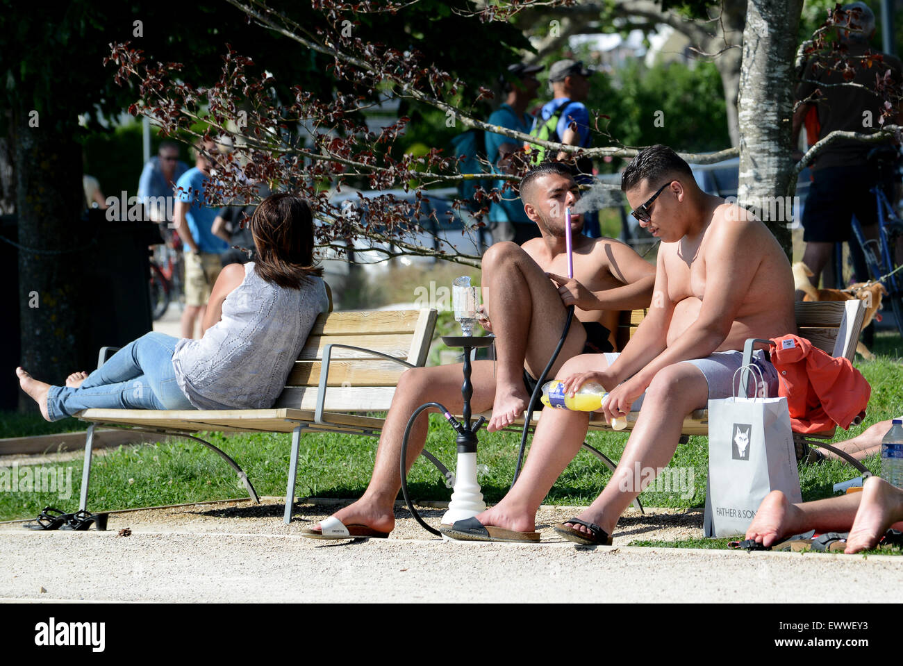 Giovani uomini di fumare un narghilè Shisha tubo in parco pubblico di Annecy Francia - Francese Foto Stock