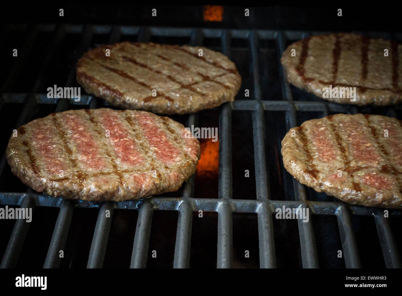 Quattro hamburger di manzo fette sul grill rack, soft focus, close up Foto Stock