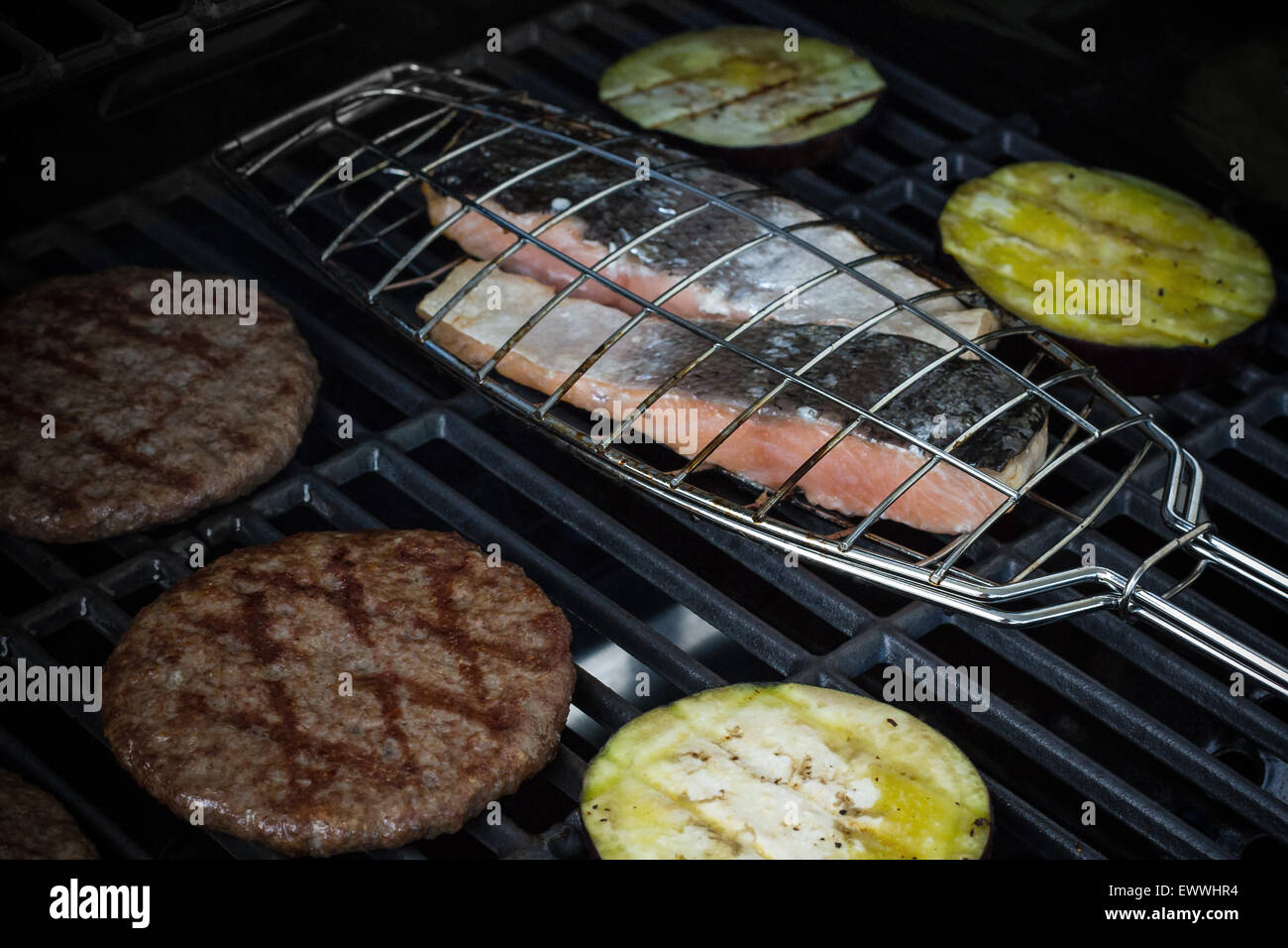 Bistecca di salmone, hamburger e fette di melanzane alla griglia, rack, soft focus Foto Stock