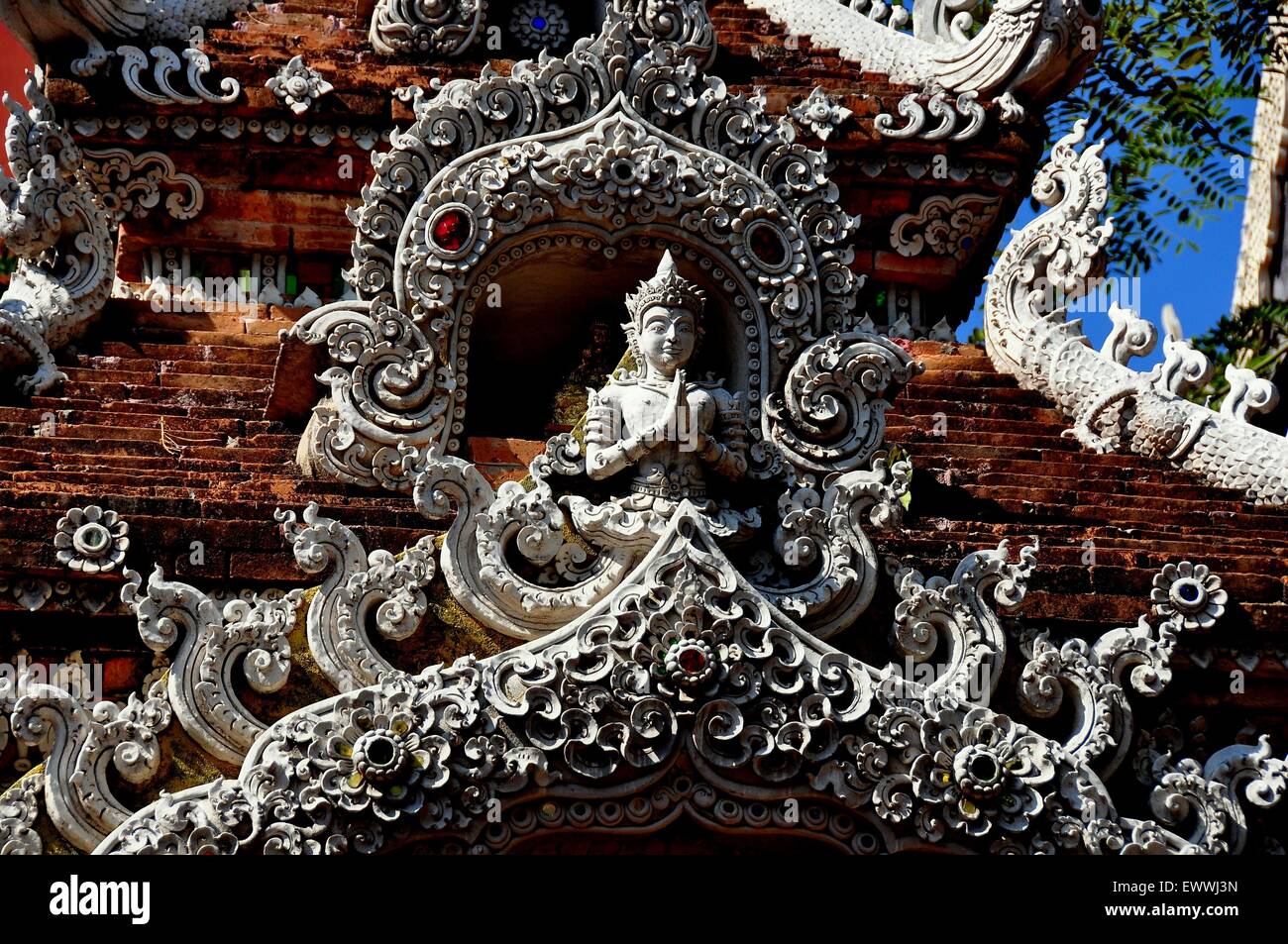 Chiang Mai, Thailandia: opulento gateway intagliate con motivi floreali e una preghiera Aponsi figura al Wat Lok Molee * Foto Stock