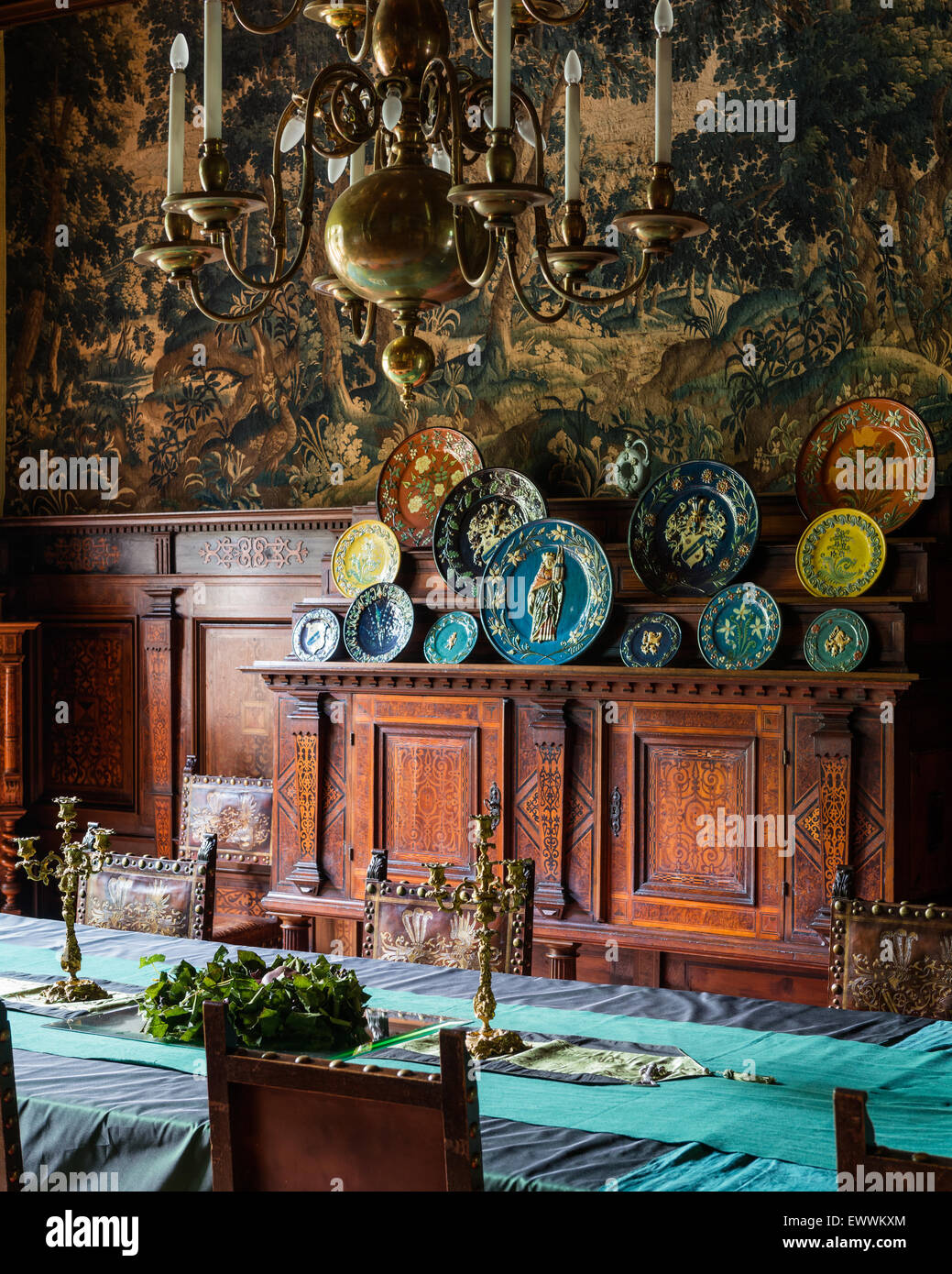 Ornati cabinet in legno con piatti decorativi in sala da pranzo con lampadario in ottone Foto Stock