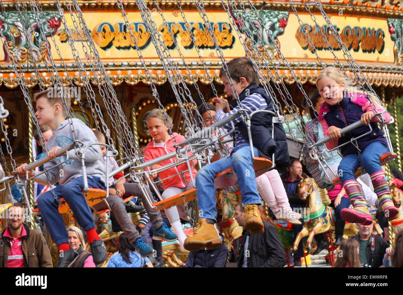 Bambini su un stile vintage swing catena ride a Chatsworth Country Fair Derbyshire England Regno Unito Foto Stock