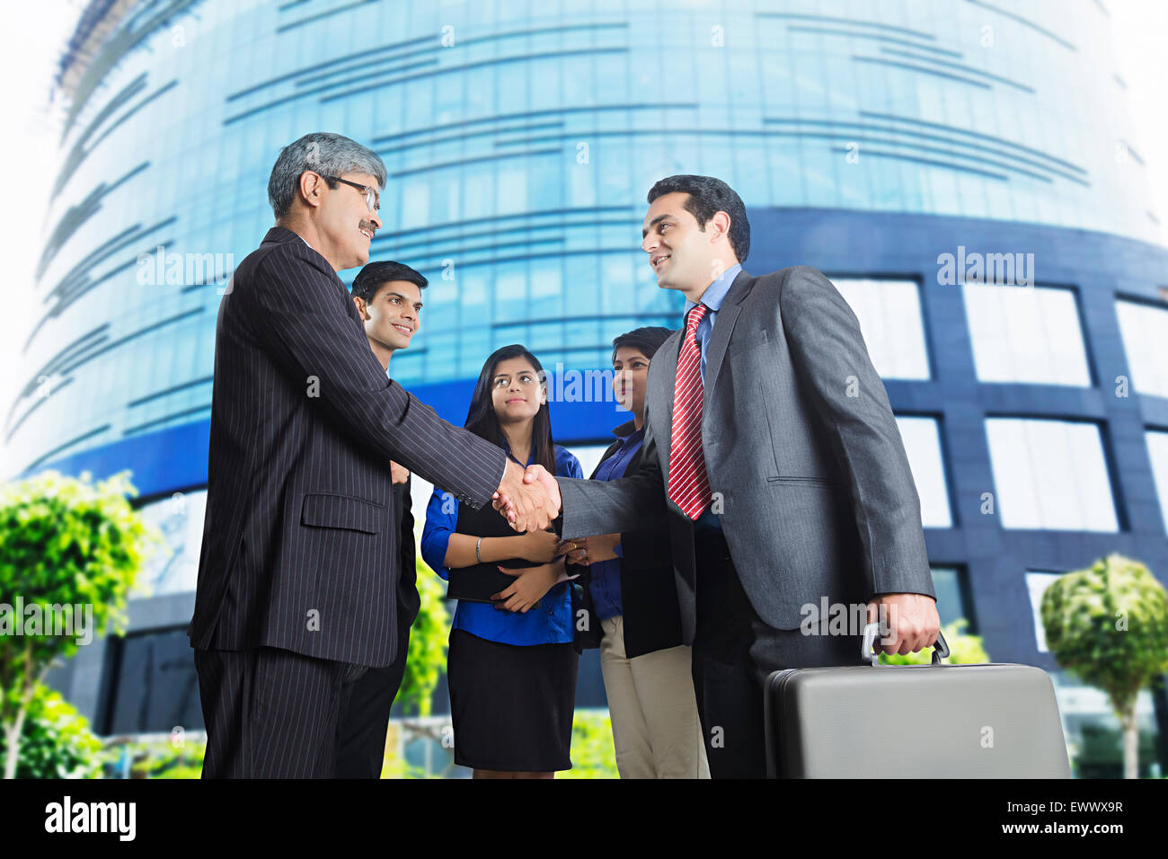 4 Indian business partner che si occupano di handshake Foto Stock