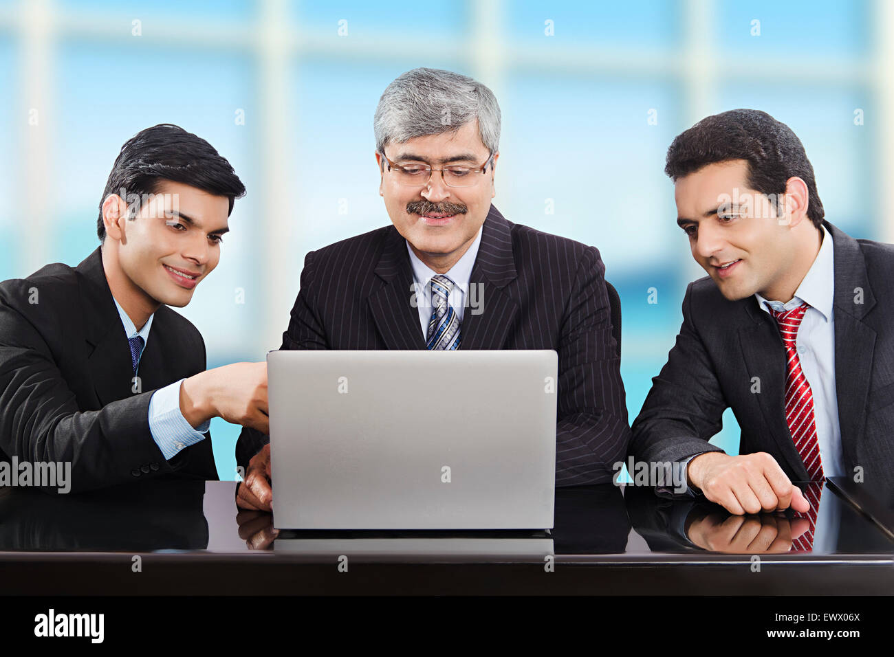 3 Indian business partner di discussione per laptop Foto Stock