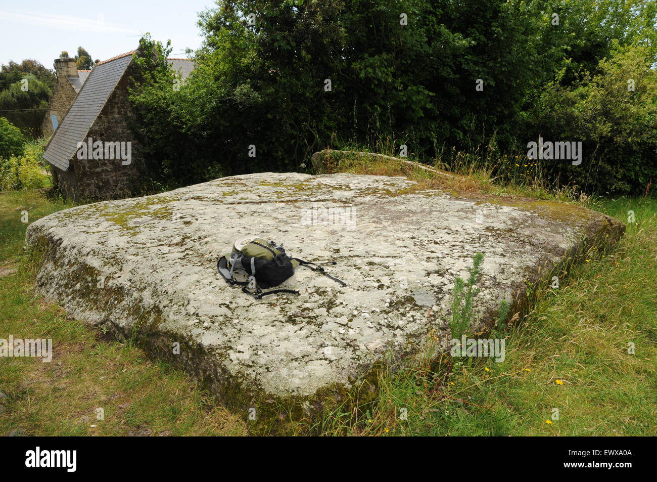 Un cappuccio pietra sulla sommità del Mané-Lud Dolmen a Locmariaquer, Brittany. Lo zaino dà un'idea delle dimensioni di questa pietra. Foto Stock
