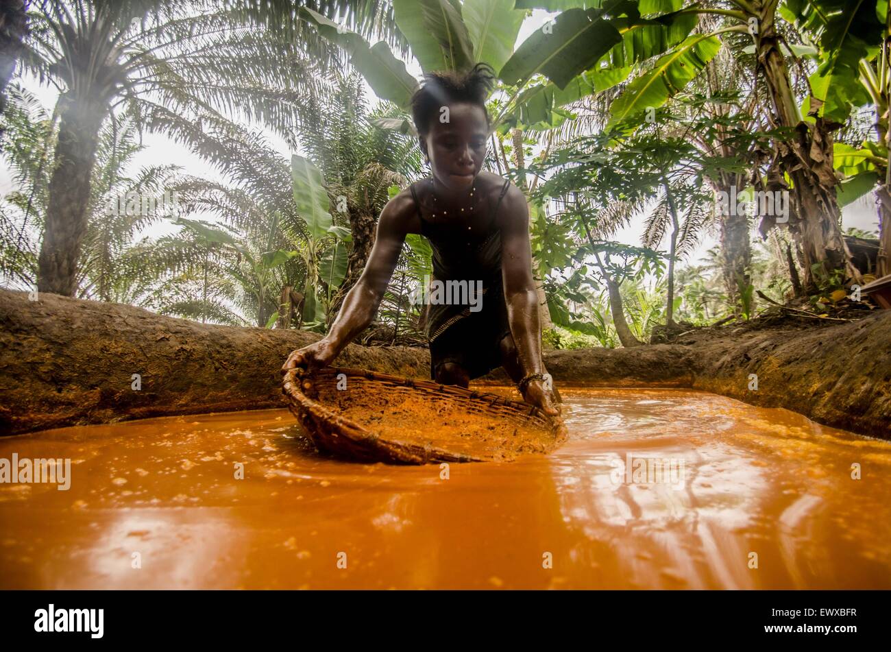 Una donna la preparazione di olio di palma in una fattoria in Sierra Leone. Foto Stock